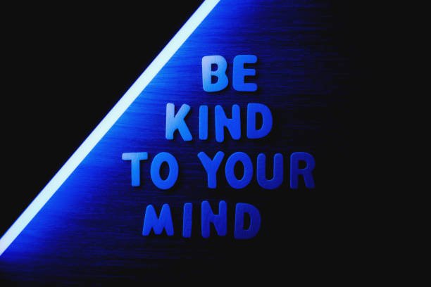 be kind to your mind wooden letters with blue neon lightning, flat lay
